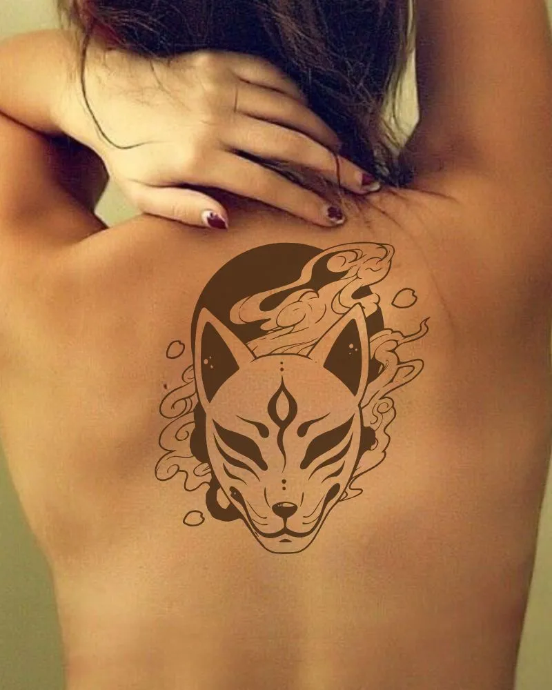 a woman seen from behind with a kitsune mask tattoo on her back