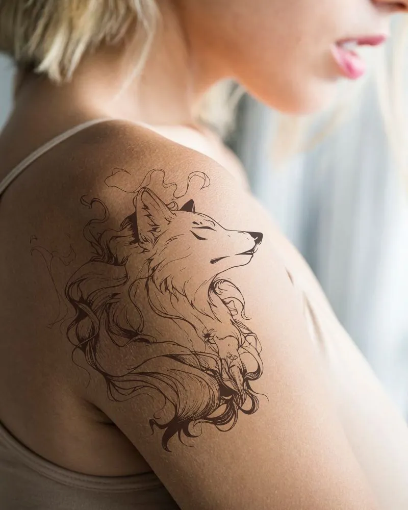 A photograph of a woman in profile with a kitsune fox tattoo on her shoulder.